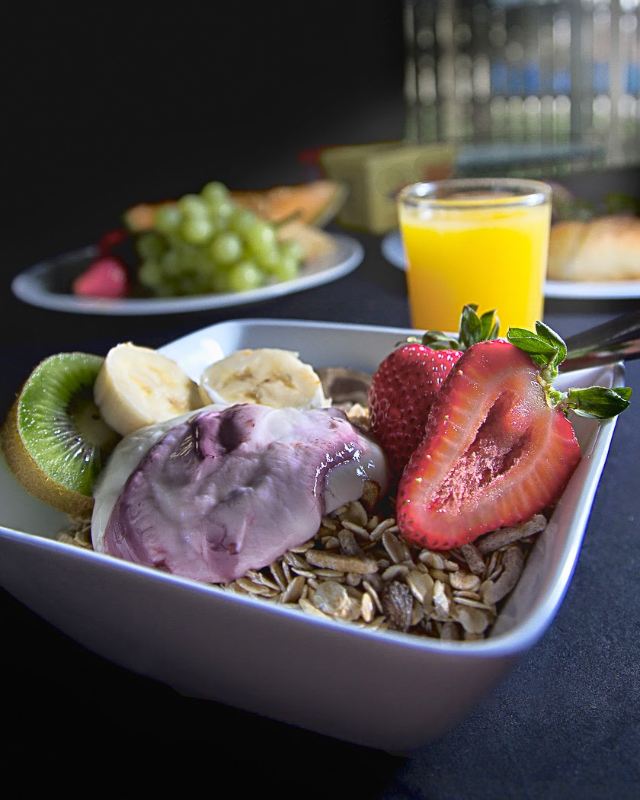 A bowl of cereal topped with fresh fruit and creamy yogurt, creating a delicious and nutritious breakfast option.