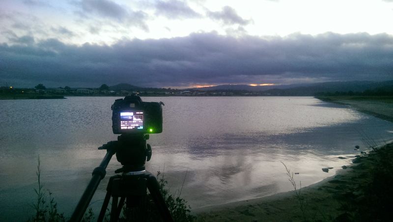 Nikon on tripos at lake - A camera on a tripod capturing the serene beauty of a lake.